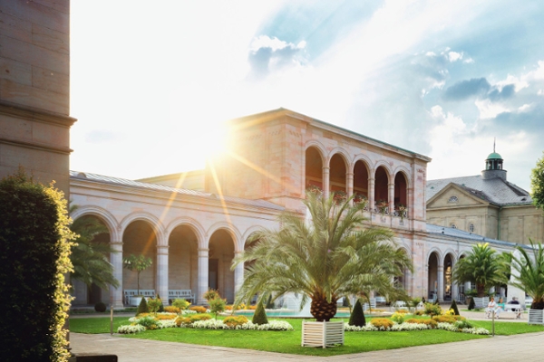 Kurgarten mit Arkadenbau und Sonne im Hintergrund  Kurgarten mit Arkadenbau und Sonne im Hintergrund